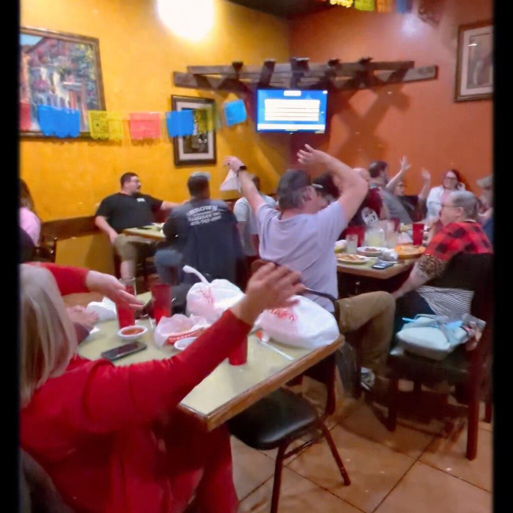 Trivia night crowd celebrating at their tables