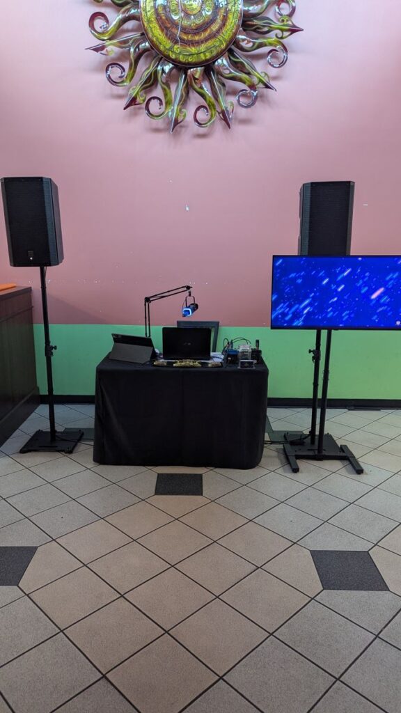 DJ booth, speakers and screen set up for trivia night