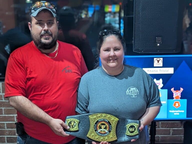 Trivia night winners holding the Tough Toro championship belt
