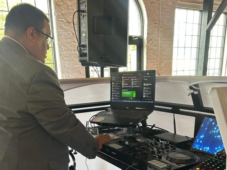 Jesse in a suit mixing at his DJ controller
